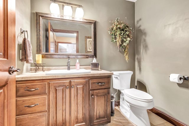 bathroom with tile patterned floors, baseboards, toilet, and vanity