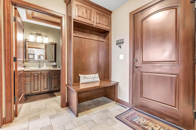 mudroom with baseboards and a sink