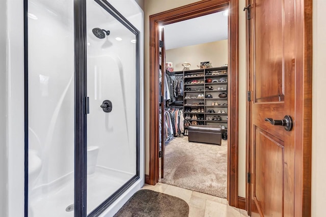 bathroom with a stall shower and a spacious closet