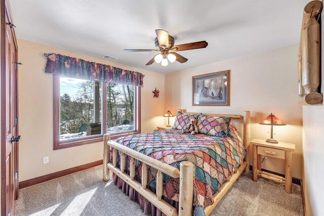 carpeted bedroom with visible vents, baseboards, and ceiling fan