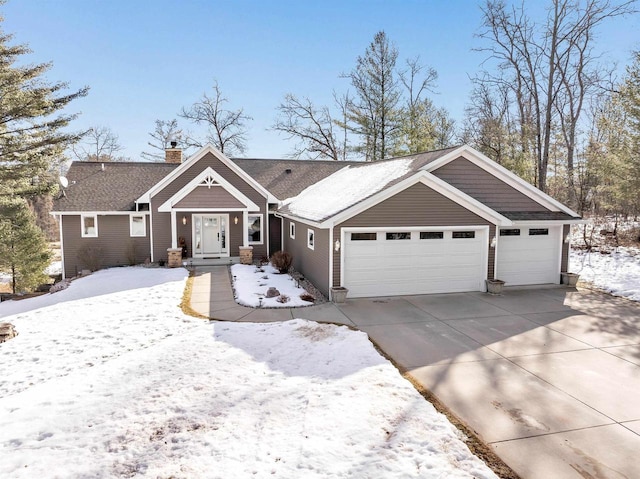 view of front of property with an attached garage, driveway, and a chimney