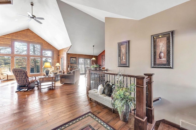 living area with visible vents, wood-type flooring, high vaulted ceiling, and a ceiling fan