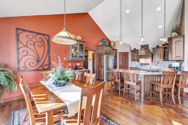 dining room featuring high vaulted ceiling and wood finished floors