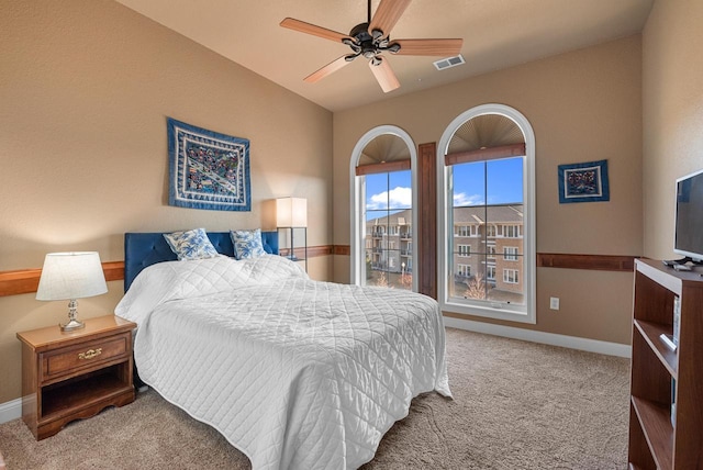 carpeted bedroom featuring visible vents, baseboards, ceiling fan, and vaulted ceiling