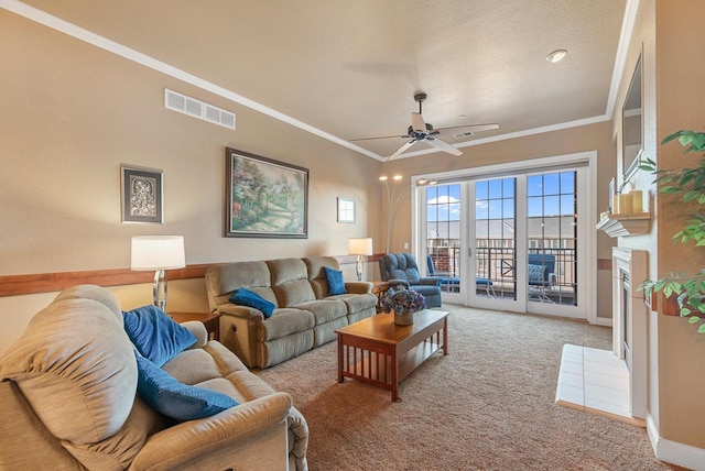 carpeted living area featuring crown molding, baseboards, visible vents, and ceiling fan