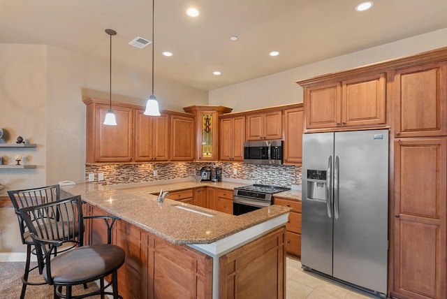 kitchen featuring visible vents, a sink, stainless steel appliances, a peninsula, and light stone countertops