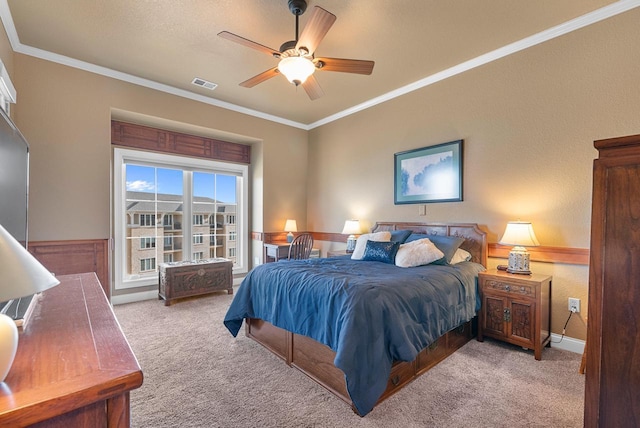 bedroom with visible vents, carpet floors, ornamental molding, and a ceiling fan