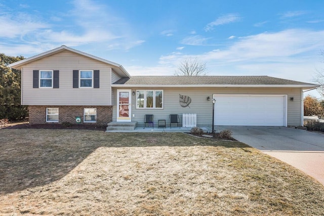 tri-level home featuring concrete driveway, an attached garage, and a front yard