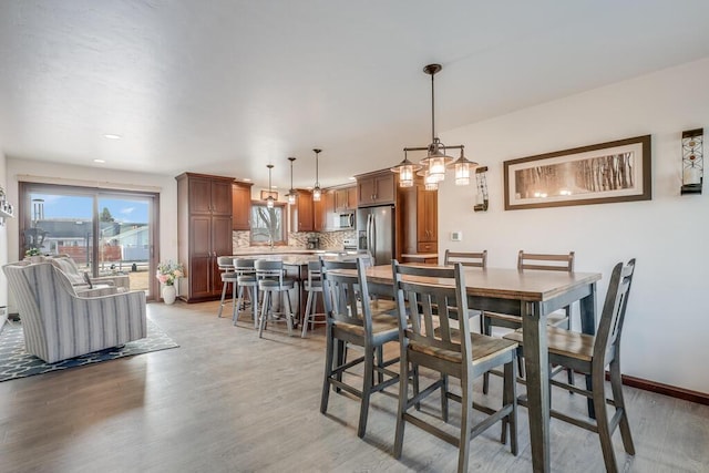 dining area with baseboards and light wood-style floors