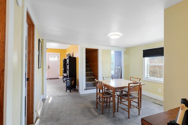 dining space featuring baseboards, stairs, and carpet