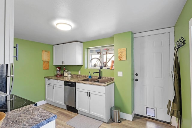 kitchen with a sink, stainless steel dishwasher, fridge, light wood-style floors, and white cabinets