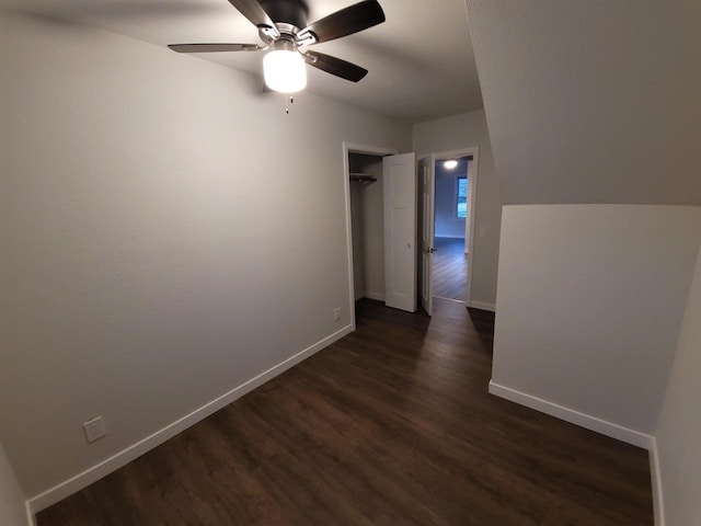 corridor with baseboards and dark wood-style flooring