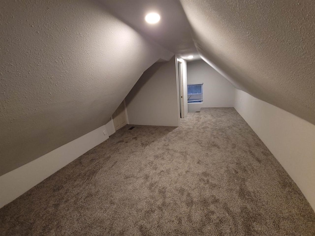 bonus room featuring a textured ceiling, carpet, and vaulted ceiling