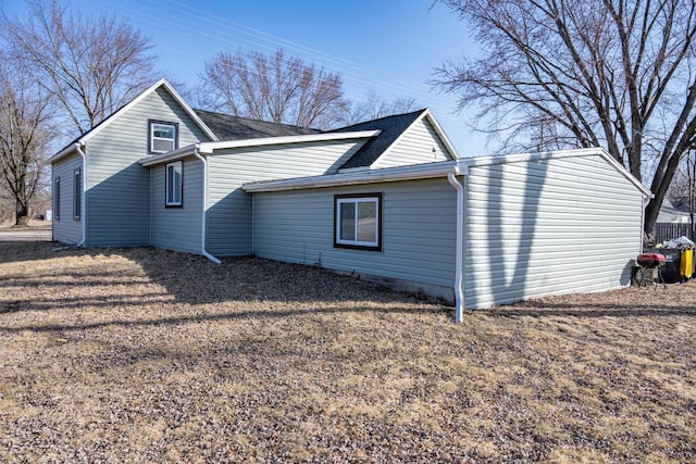 view of side of property with roof with shingles