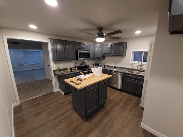 kitchen featuring a center island, dark wood-style floors, appliances with stainless steel finishes, and a sink