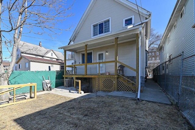 back of property featuring a porch and fence