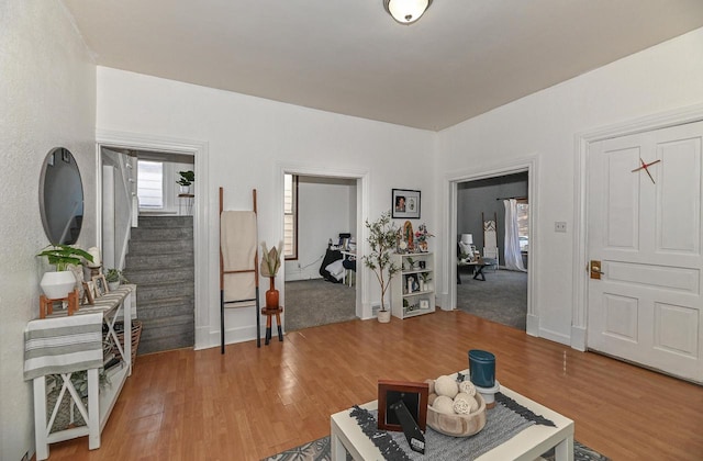 living room featuring stairway, baseboards, and light wood-style flooring