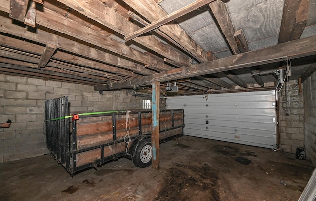 garage with concrete block wall and a garage door opener