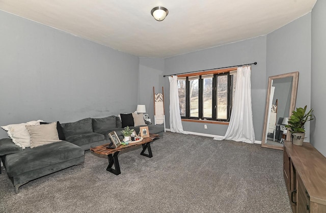 living area featuring dark carpet and baseboards