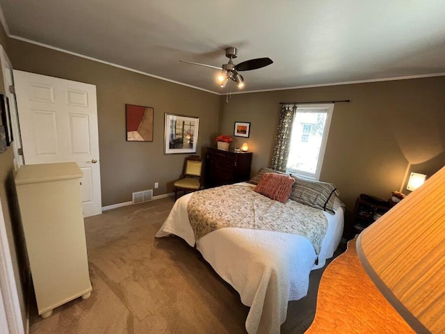 carpeted bedroom featuring ceiling fan, baseboards, visible vents, and ornamental molding