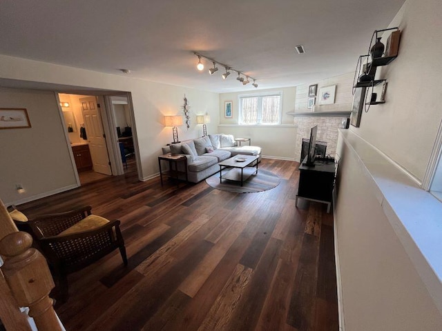 living area with visible vents, baseboards, a fireplace, and dark wood-style flooring