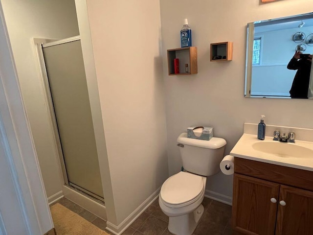 bathroom featuring tile patterned flooring, a shower stall, baseboards, toilet, and vanity