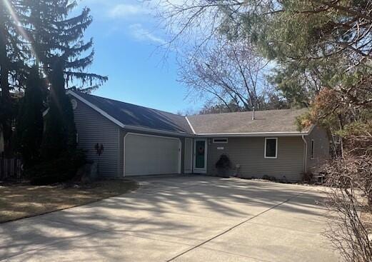 single story home featuring concrete driveway and an attached garage