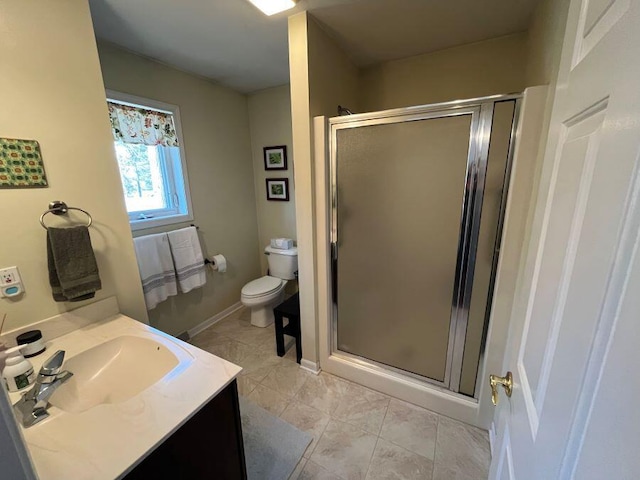 full bathroom featuring baseboards, toilet, a stall shower, and vanity