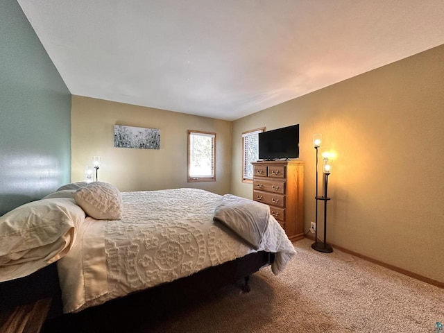 bedroom featuring light colored carpet and baseboards