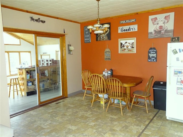 dining room with baseboards, crown molding, and stone finish floor