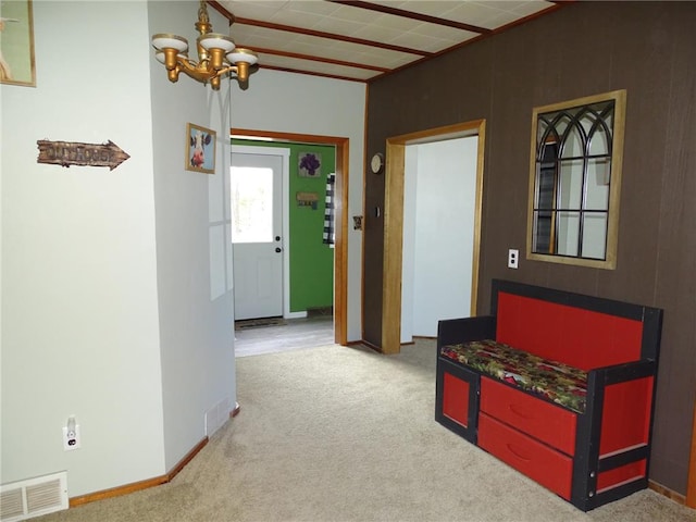 hall with baseboards, visible vents, carpet floors, and an inviting chandelier