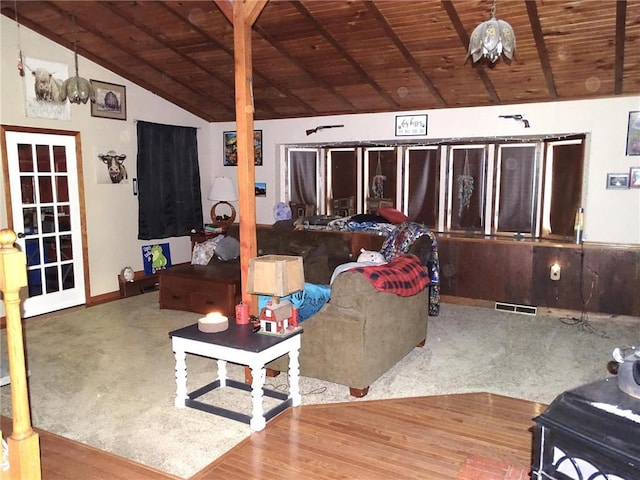 carpeted living area with wood finished floors, visible vents, baseboards, vaulted ceiling, and wood ceiling