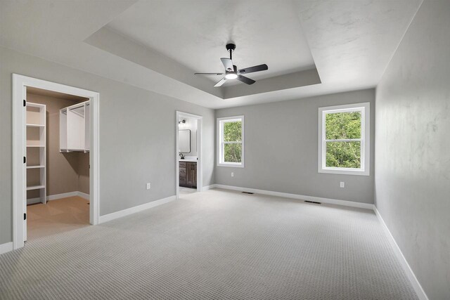 2570 Meyer Way, De Pere, WI 54115 - unfurnished bedroom featuring light carpet, a raised ceiling, baseboards, a spacious closet, and a ceiling fan
