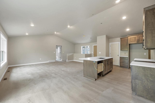 2570 Meyer Way, De Pere, WI 54115 - kitchen featuring a center island, lofted ceiling, baseboards, light countertops, and brown cabinets
