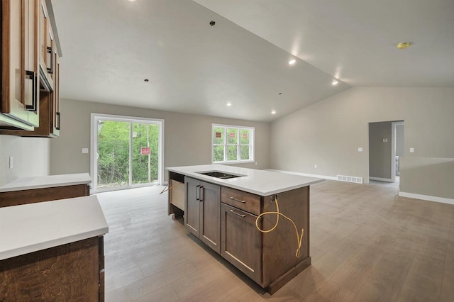 2570 Meyer Way, De Pere, WI 54115 - kitchen featuring vaulted ceiling, light wood-style floors, an island with sink, light countertops, and open floor plan