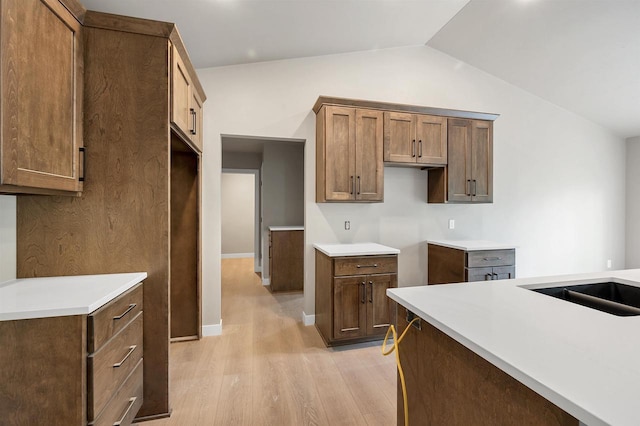 2570 Meyer Way, De Pere, WI 54115 - kitchen with light wood-style floors, vaulted ceiling, a sink, and light countertops