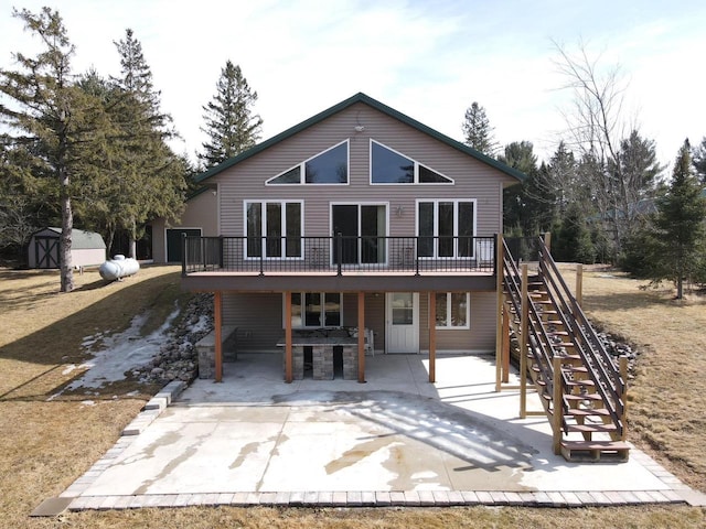 rear view of house with a patio, an outdoor structure, a deck, and stairs