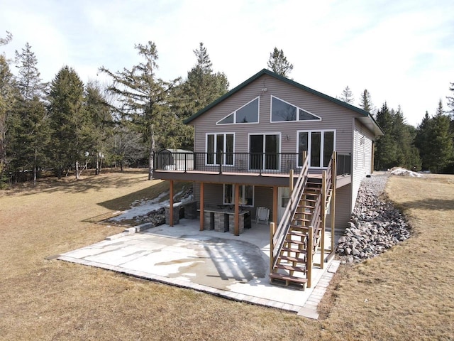 rear view of property featuring stairway, a wooden deck, and a patio area