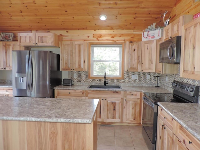 kitchen with a sink, light tile patterned floors, light brown cabinetry, and stainless steel appliances