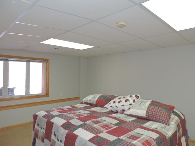 bedroom with carpet flooring, a paneled ceiling, and baseboards