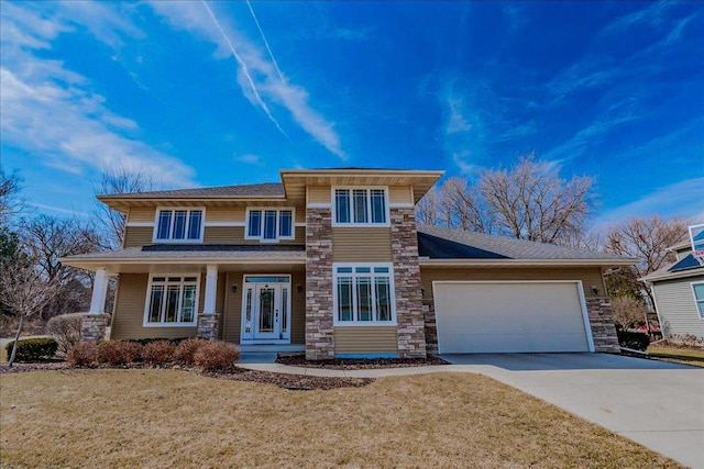 view of front of property featuring a garage, stone siding, a front lawn, and driveway