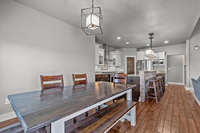 dining room with recessed lighting, baseboards, and wood finished floors