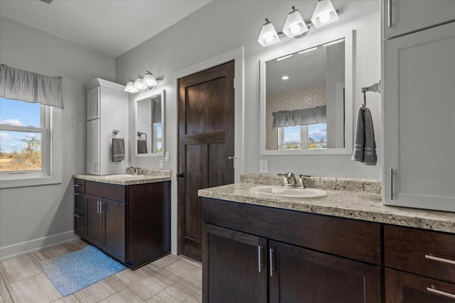 bathroom featuring plenty of natural light, two vanities, and a sink