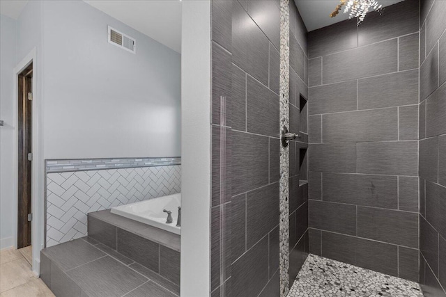 bathroom with visible vents, a tile shower, tile patterned flooring, a garden tub, and tile walls