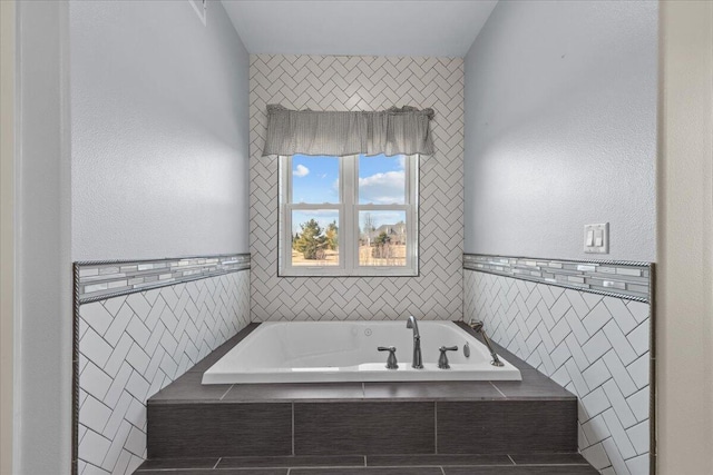 full bath featuring tile walls and a garden tub