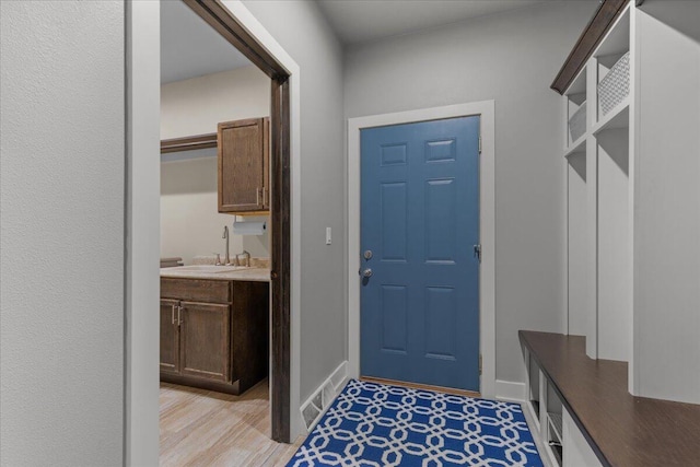 mudroom with baseboards and a sink