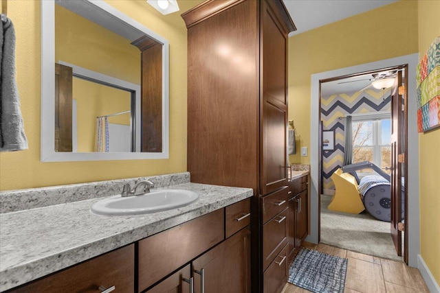 ensuite bathroom featuring vanity, baseboards, and ensuite bathroom