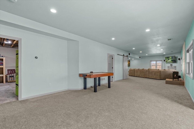 carpeted living area featuring a barn door, recessed lighting, and baseboards