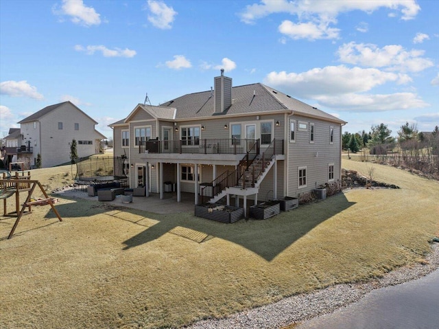 rear view of house featuring a lawn, a chimney, stairs, and a patio area