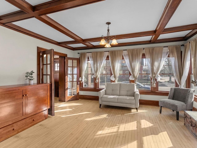 sitting room featuring light wood-type flooring, baseboards, coffered ceiling, and a chandelier